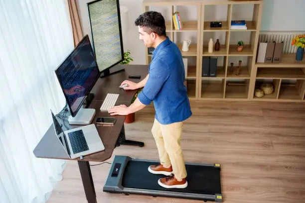 travailler en marchant : homme sur tapis de marche à son poste de travail